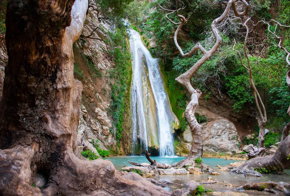 A guided group enjoying river trekking in Greece at the stunning Neda waterfalls.