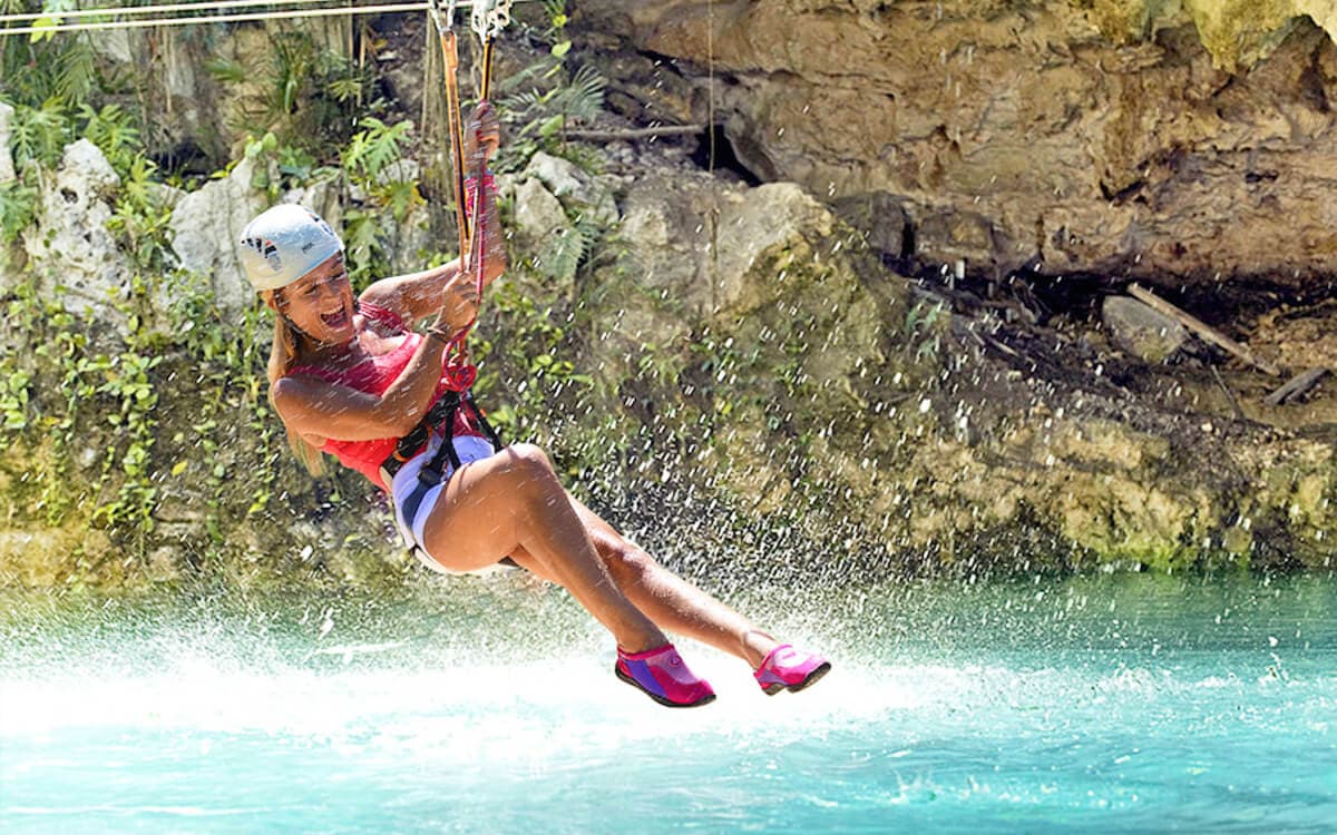 Woman riding the zipline during the Polylimnio Waterfalls Canyoning tour